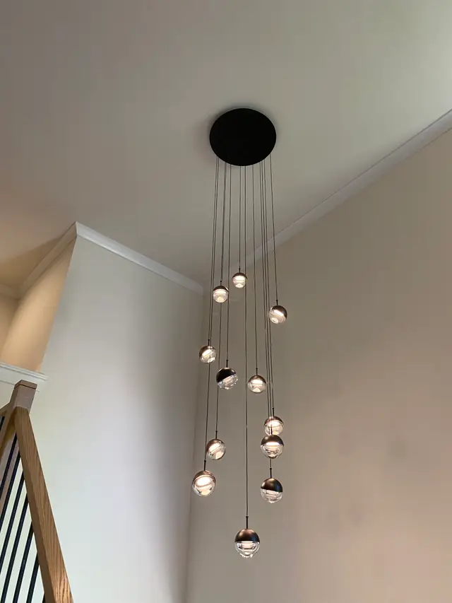 Multi-globe pendant chandelier installed over a stairwell