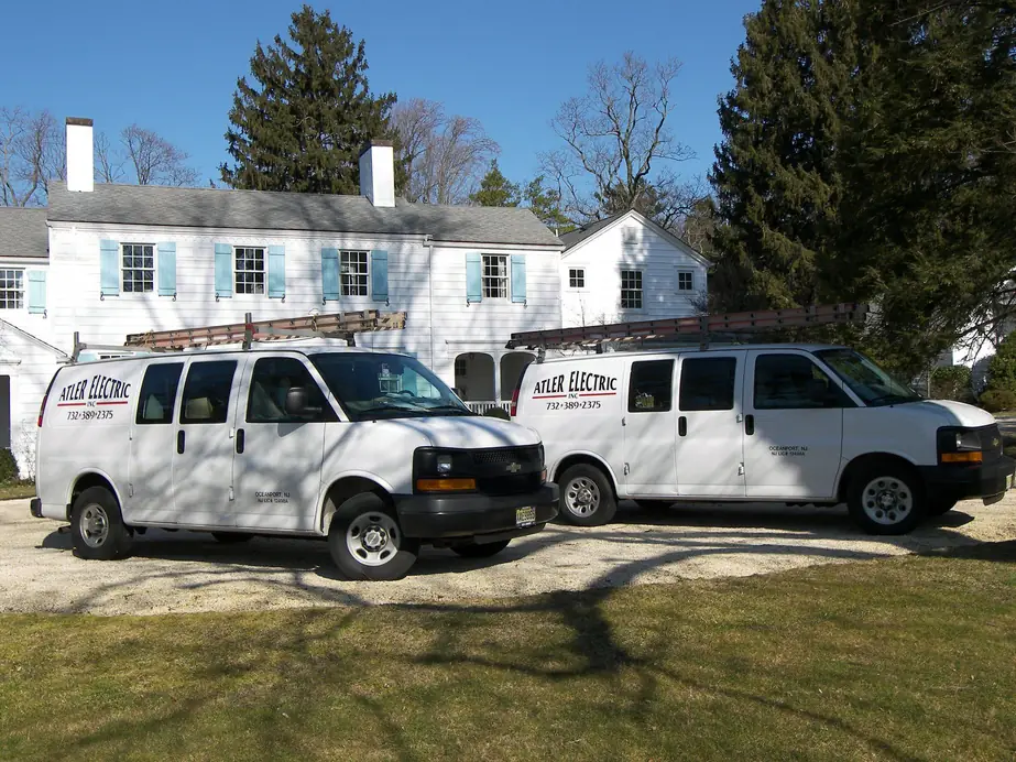 Two branded Atler Electric Inc vans parked outside a residential job in Monmouth County